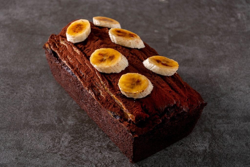Chocolate banana bread topped with halved bananas