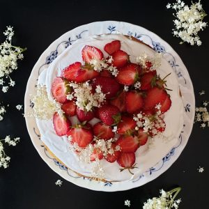 Strawberry elderflower layer cake decorated with fresh strawberries