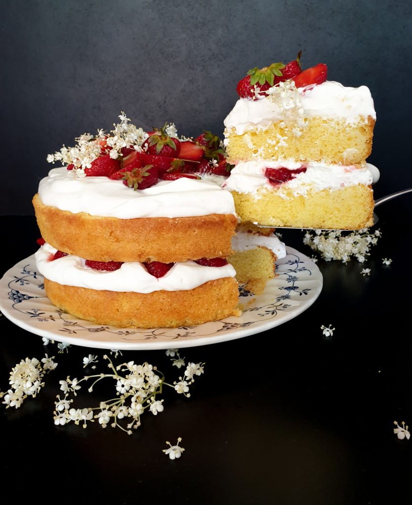 Slice of strawberry elderflower cake with mascarpone chantilly