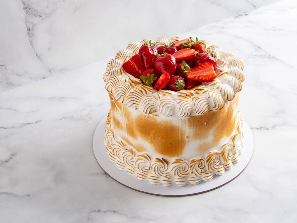 Strawberry mascarpone cake covered in torched Italian meringue